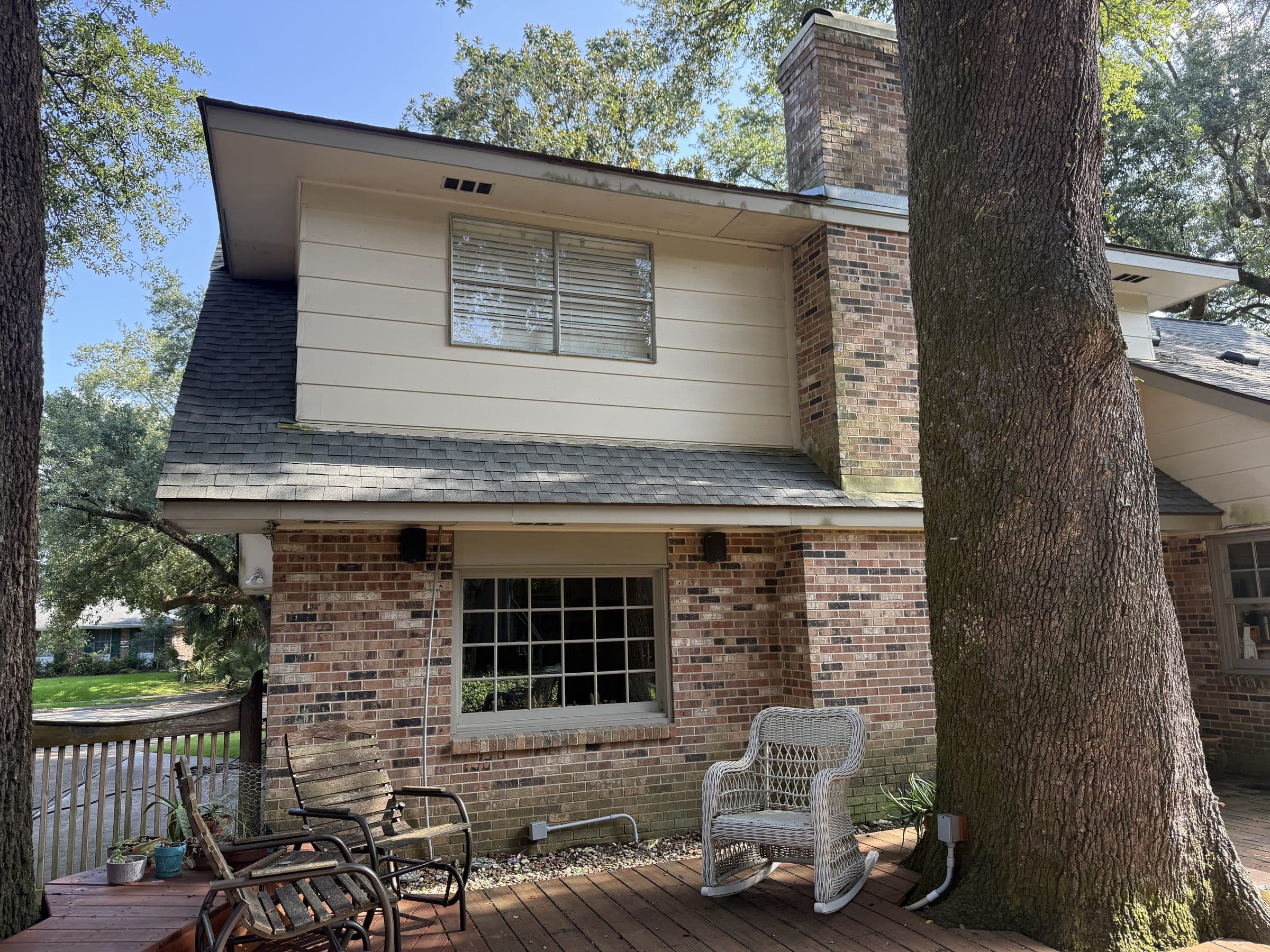 Brick home with chimney and covered porch cleaned by Elite Softwash Nola