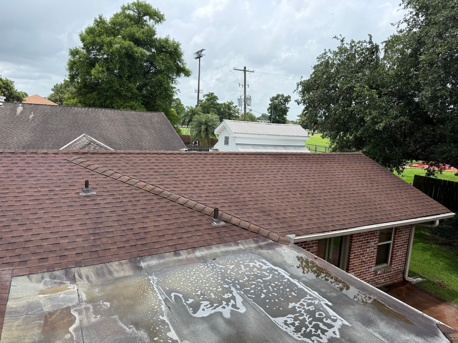 Soft wash solution running down a shingle roof